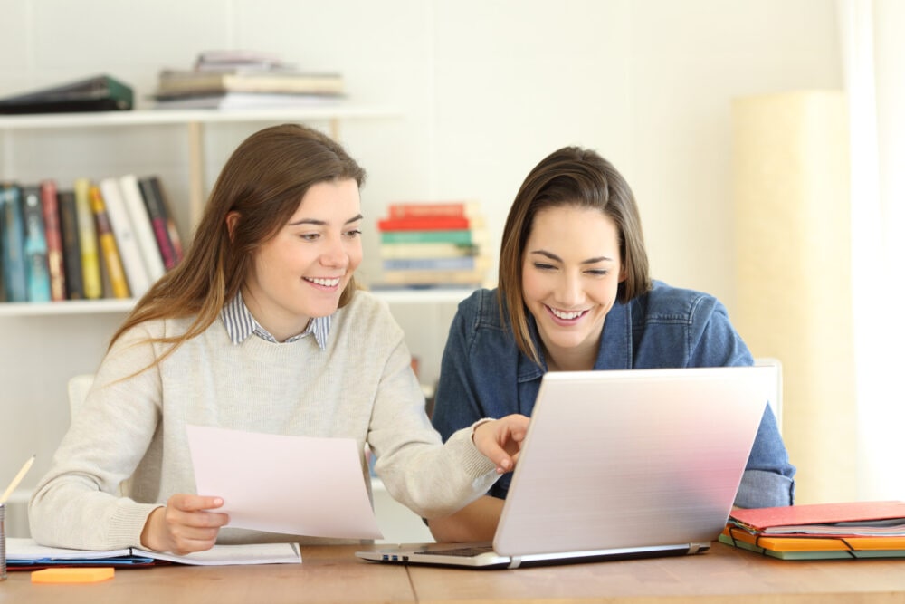two students learning together on laptop