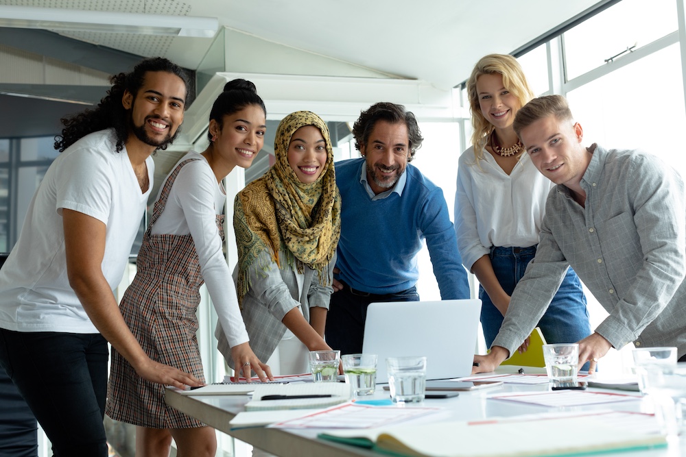 Business people looking at camera while working together at conference room in a modern office