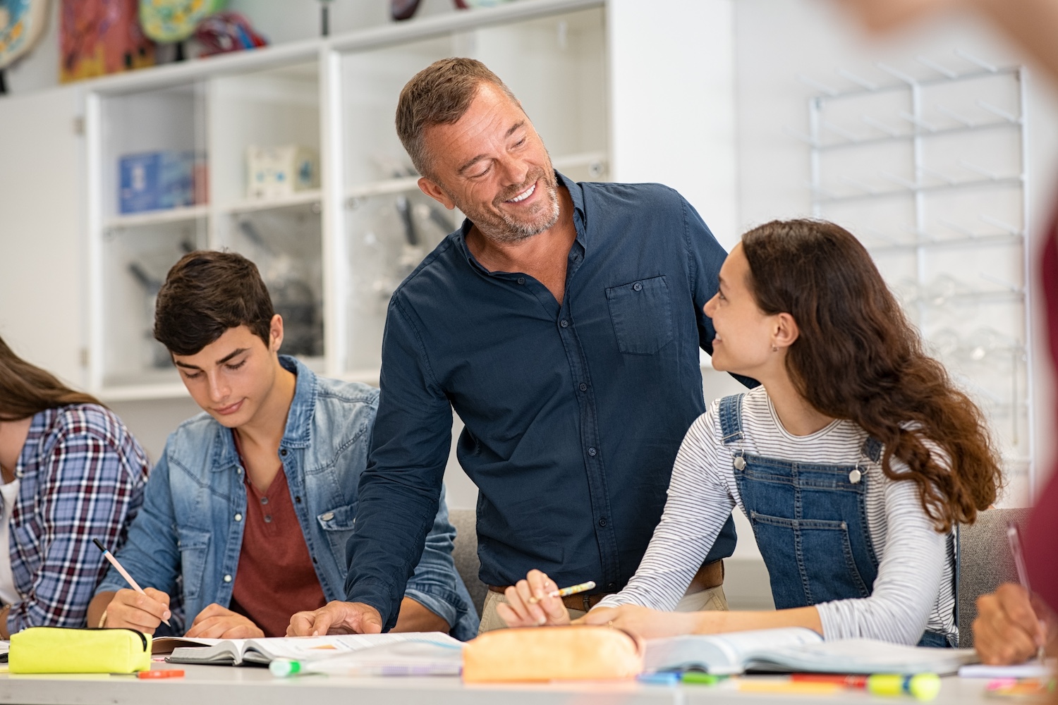 Teacher helping his students