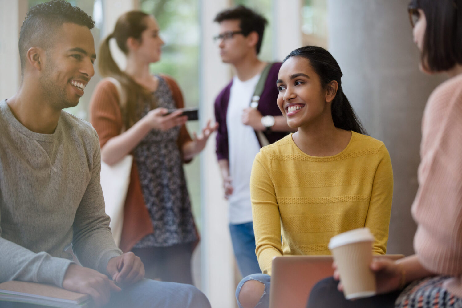 Smiling college students studying drinking coffee