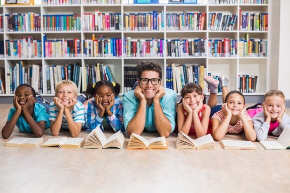 Teacher and kids lying on floor in library